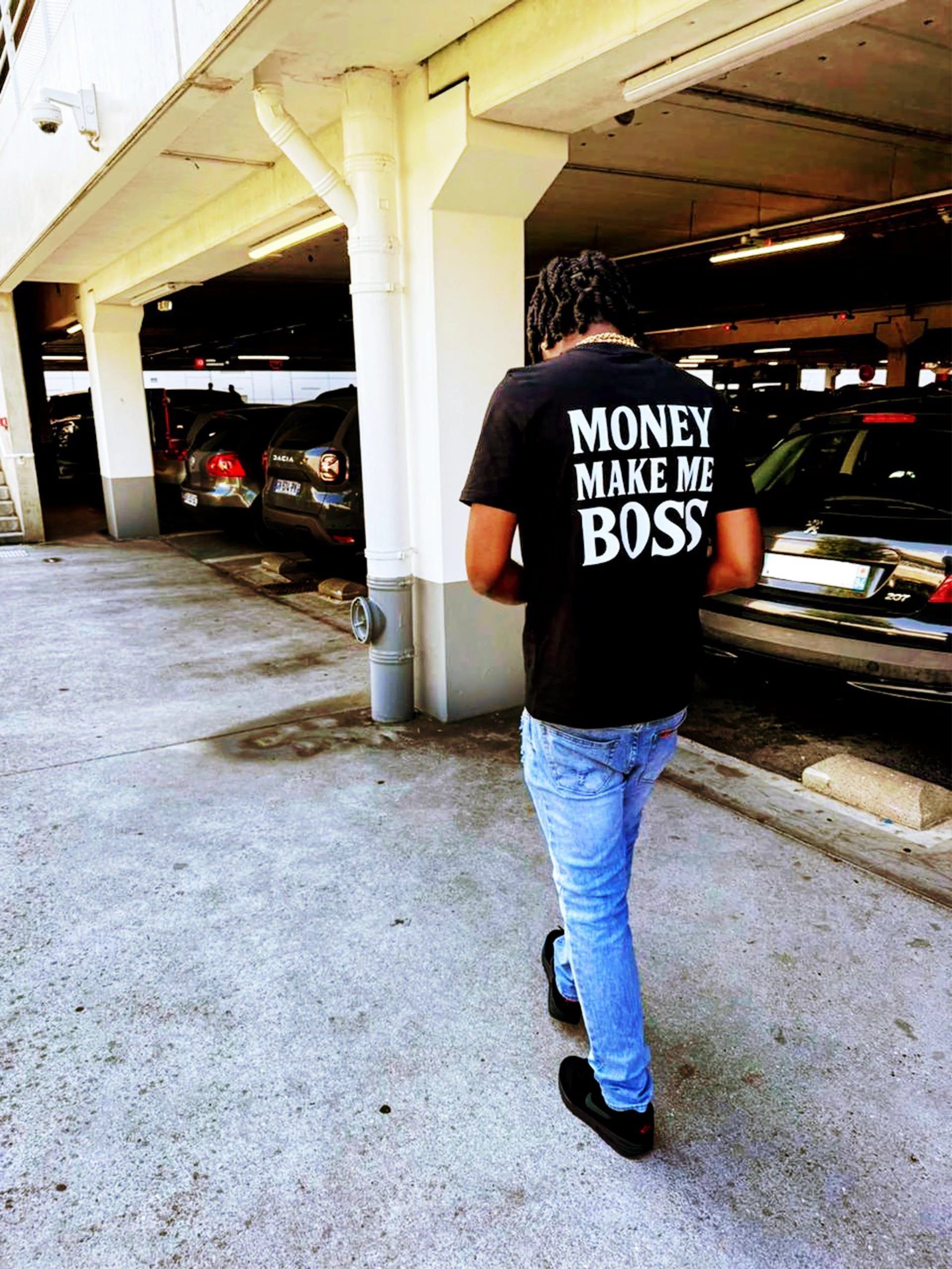 Photographie d'un homme portant t-shirt avec écrit au dos money make me boss